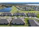 Aerial view of the community showcasing lush landscaping, golf course, and beautiful lake at 2820 Attwater Loop, Winter Haven, FL 33884