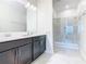 Modern bathroom with dual sink vanity and glass-enclosed shower at 2820 Attwater Loop, Winter Haven, FL 33884
