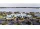 An aerial shot of a community clubhouse on a lakefront property with tennis courts and a well-manicured landscape at 2820 Attwater Loop, Winter Haven, FL 33884