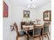 Formal dining area with a wooden table, leather chairs, chandelier, and decorative artwork at 2820 Attwater Loop, Winter Haven, FL 33884