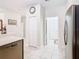 Bright hallway view of the stainless refrigerator, white pantry door, and open doorways to other rooms at 2820 Attwater Loop, Winter Haven, FL 33884