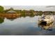 People enjoying a boat ride on the calm lake, with a dock and gazebo in the background at 2820 Attwater Loop, Winter Haven, FL 33884