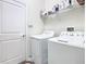Functional laundry room with a washer, dryer, and storage shelves, plus a utility sink at 2820 Attwater Loop, Winter Haven, FL 33884