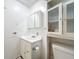 Bathroom with a toilet, sink, mirror, and cabinet storage at 3025 Canandaigua Trl, Lakeland, FL 33810