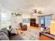 Spacious living room featuring wood floors, neutral walls, and a sliding glass door leading to an enclosed porch at 3025 Canandaigua Trl, Lakeland, FL 33810