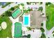 Aerial view of community with mature trees, green space, parking, swimming pool, and tennis courts at 3158 Pebble Bend Dr, Lakeland, FL 33810