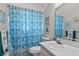 Bathroom with a seashell-themed shower curtain, white vanity, and decorative accents at 3158 Pebble Bend Dr, Lakeland, FL 33810