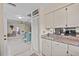 Bright kitchen with white cabinets and view into the living and dining area at 3158 Pebble Bend Dr, Lakeland, FL 33810