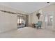Open living room with neutral carpet, glass sliding door to sunroom, and decorative wall accents at 3158 Pebble Bend Dr, Lakeland, FL 33810