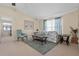Comfortable living room featuring natural light, floral sofa, accent chair, and coastal-themed artwork at 3158 Pebble Bend Dr, Lakeland, FL 33810