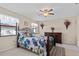 Cozy bedroom showcasing a ceiling fan, ample natural light, and charming floral accents at 3158 Pebble Bend Dr, Lakeland, FL 33810