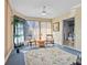 Bright sunroom showcasing a cozy seating area with a ceiling fan, natural light, and an entrance to the bathroom at 3158 Pebble Bend Dr, Lakeland, FL 33810