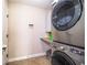 Practical laundry area with stacked washer and dryer, storage, and tiled floor at 3510 Kenwood Xing, Lakeland, FL 33812