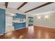 Inviting living room with wood floors and striking wooden beam ceiling, leading to a kitchen with blue cabinets at 3511 Southcrest Blvd, Lakeland, FL 33812