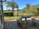 Backyard patio featuring a stone table and benches, landscaping, lawn and water views at 394 Nolane Ln, Polk City, FL 33868
