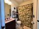 Bathroom with a sink, toilet, shower with tropical leaf curtain, and storage rack at 394 Nolane Ln, Polk City, FL 33868