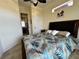 Bright bedroom featuring a tropical themed bedspread, modern ceiling fan and decorative palm tree art at 394 Nolane Ln, Polk City, FL 33868