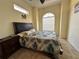 Bedroom with a palm themed bedspread, arched window letting in lots of natural light, and tiled flooring at 394 Nolane Ln, Polk City, FL 33868