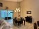 Dining room with an elegant chandelier and direct access to the lanai and living room at 394 Nolane Ln, Polk City, FL 33868