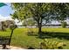 Expansive backyard with lush green grass, a mature tree and a view of the lake at 3976 Cypress W Lndg, Winter Haven, FL 33884