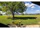 View of a well maintained, sun dappled backyard that extends to the lakeside at 3976 Cypress W Lndg, Winter Haven, FL 33884