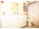 Bathroom featuring white vanity with elegant hardware, framed mirror, and tub with raindrop curtain at 3976 Cypress W Lndg, Winter Haven, FL 33884
