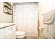 Bathroom featuring white vanity with chrome hardware, shower with raindrop curtain, and updated shelving at 3976 Cypress W Lndg, Winter Haven, FL 33884