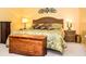 Cozy bedroom with a wicker headboard and a wooden chest, creating a relaxing retreat at 3976 Cypress W Lndg, Winter Haven, FL 33884