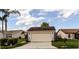 Spacious two-car garage with lovely landscaping, offering ample parking and curb appeal at 3976 Cypress W Lndg, Winter Haven, FL 33884