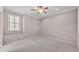This neutral bedroom has a ceiling fan, window with shutters, and carpet at 42 Enclave Dr, Winter Haven, FL 33884