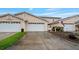 Charming townhome featuring a two-car garage, light pink exterior, and well-manicured lawn at 42 Enclave Dr, Winter Haven, FL 33884