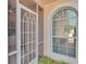 Screened front porch has arched window, a white frame, and green plants at 42 Enclave Dr, Winter Haven, FL 33884