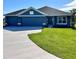 Charming blue single-story home with a well-manicured lawn and a three-car garage, perfect for Gathering living at 4202 Teeling Ct, Auburndale, FL 33823