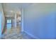 Bright hallway with tile flooring, leading to a kitchen with white cabinets and a room with double doors at 4202 Teeling Ct, Auburndale, FL 33823