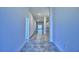 Long hallway with gray tile flooring and leads to an open-concept living space at 4202 Teeling Ct, Auburndale, FL 33823