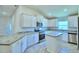 Bright kitchen featuring granite counters, white cabinetry and stainless steel appliances at 4202 Teeling Ct, Auburndale, FL 33823