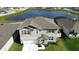 Two-story home with orange shutters and a pond in the background at 421 Chayne Pl, St Cloud, FL 34771