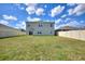 Spacious backyard with a lush green lawn, framed by a white fence, and a view of the home's exterior at 421 Chayne Pl, St Cloud, FL 34771