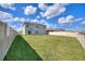 Expansive backyard featuring a well-maintained lawn, white fence, and a two-story house at 421 Chayne Pl, St Cloud, FL 34771