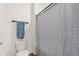 Clean bathroom with a toilet, towel rack with towel, and a bathtub with gray striped shower curtain at 421 Chayne Pl, St Cloud, FL 34771