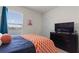 Relaxing bedroom features a bed, TV, and a view to the exterior through the window at 421 Chayne Pl, St Cloud, FL 34771
