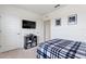 Cozy bedroom featuring a blue plaid bedspread, wall-mounted TV, and minimalist decor at 421 Chayne Pl, St Cloud, FL 34771