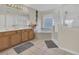 Bright bathroom featuring a double sink vanity, corner bathtub and a glass enclosed shower at 435 Gleneagles Dr, Davenport, FL 33897