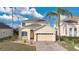Charming two-story home featuring a well-manicured lawn, brick driveway and attached two-car garage at 435 Gleneagles Dr, Davenport, FL 33897