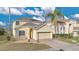 Two story home featuring a well-manicured lawn, brick driveway and an attached garage at 435 Gleneagles Dr, Davenport, FL 33897