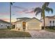 Charming two-story home with a well-manicured lawn, paved driveway, and tropical landscaping at 435 Gleneagles Dr, Davenport, FL 33897