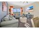 Comfortable living room featuring a large sectional sofa, patterned ottoman, and bright windows at 435 Gleneagles Dr, Davenport, FL 33897