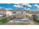 Backyard view with a screened-in pool, jacuzzi and outdoor seating area under sunny skies at 435 Gleneagles Dr, Davenport, FL 33897