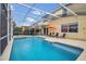 A beautiful screened pool with blue tile and outdoor umbrellas at 435 Gleneagles Dr, Davenport, FL 33897