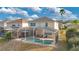 Aerial view of the backyard featuring a screened-in pool, jacuzzi and outdoor seating at 435 Gleneagles Dr, Davenport, FL 33897